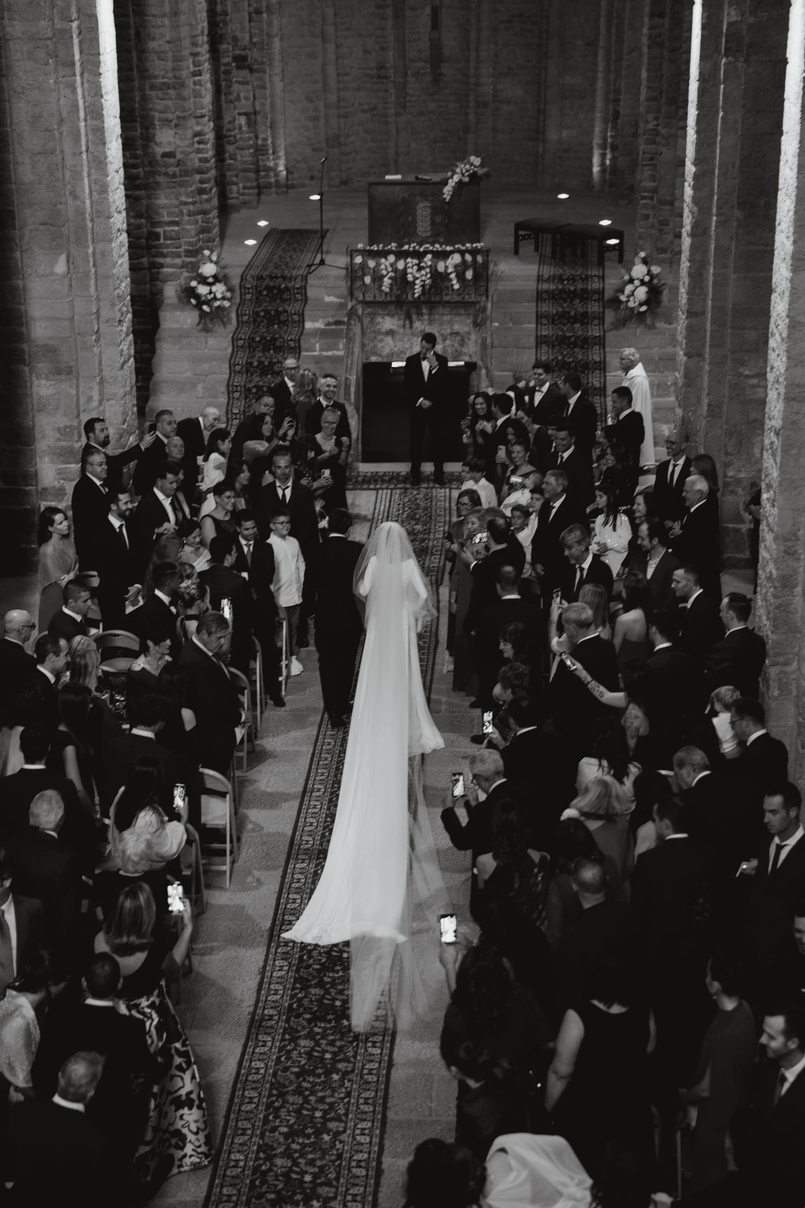 Ceremonia vista desde arriba con los invitados en pie, en blanco y negro