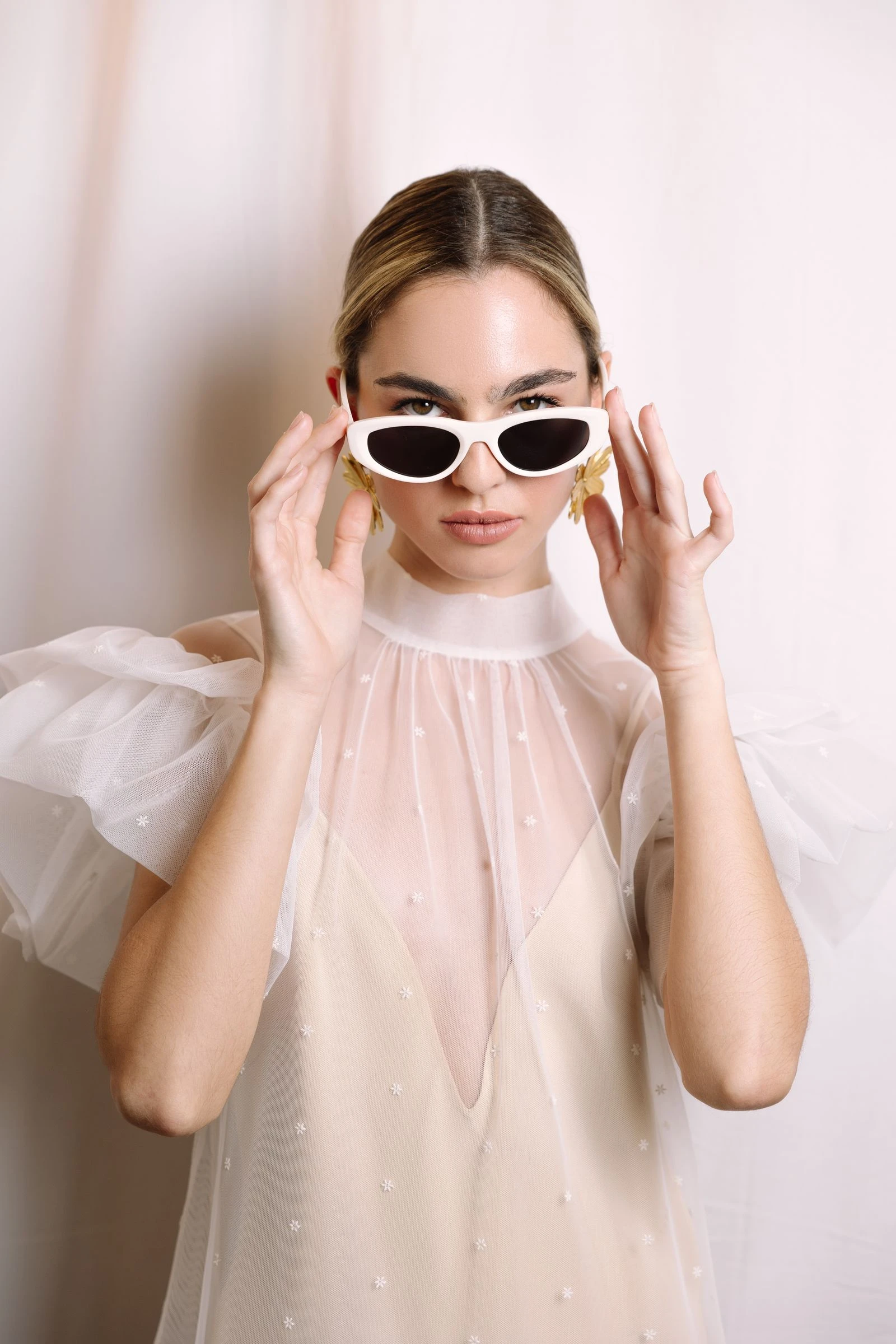 Retrato de novia con gafas de sol y blusa de tul
