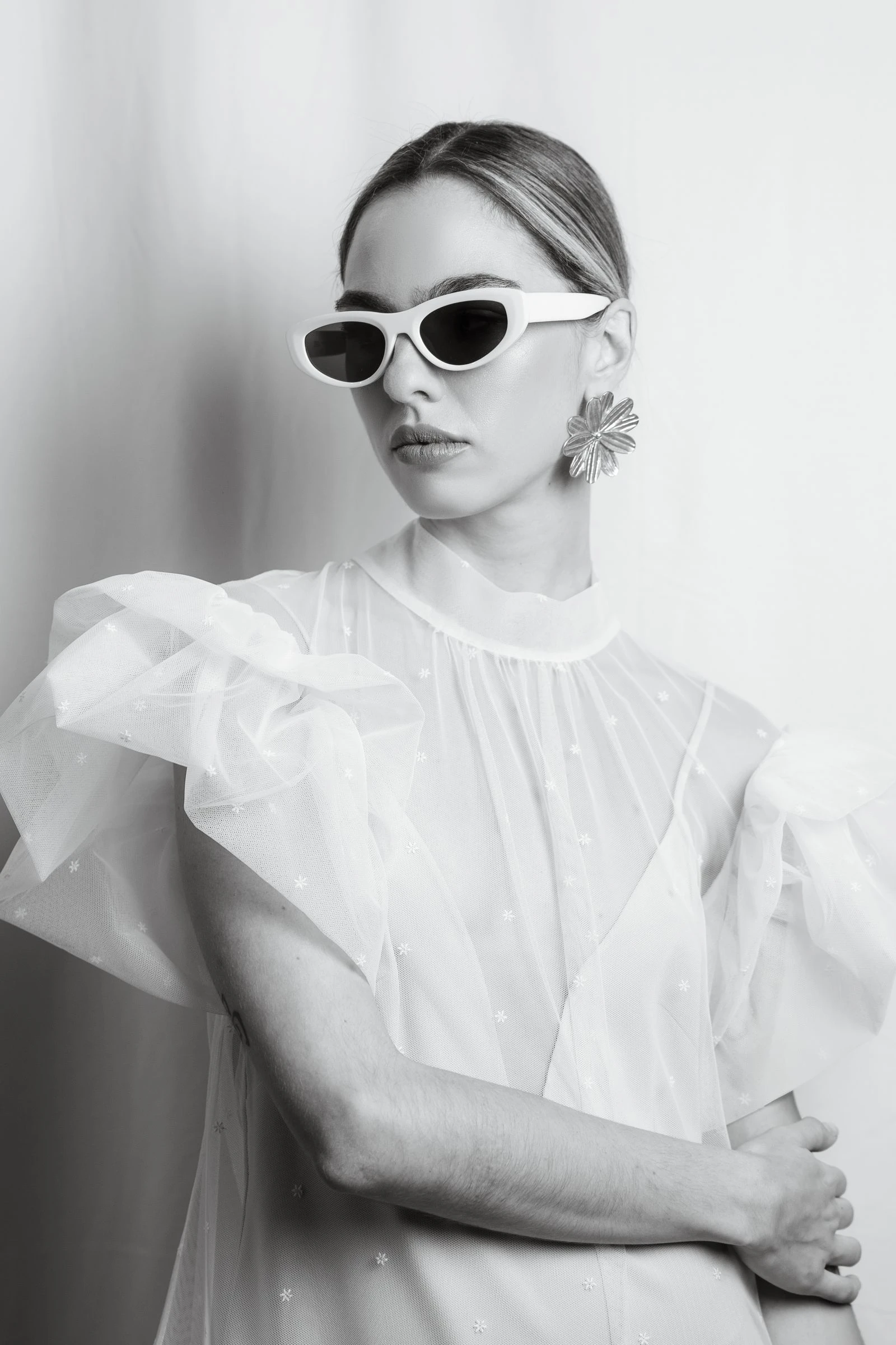 Retrato de novia con gafas de sol y blusa de volantes, en blanco y negro