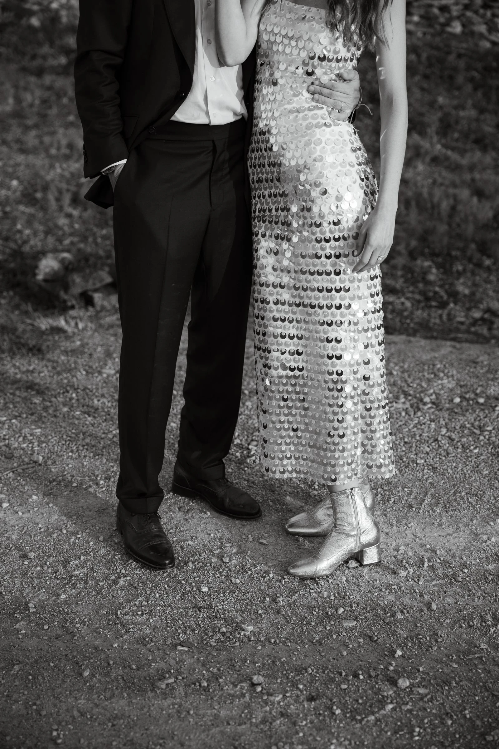 Novios de pie juntos, ella con vestido de lentejuelas, en blanco y negro