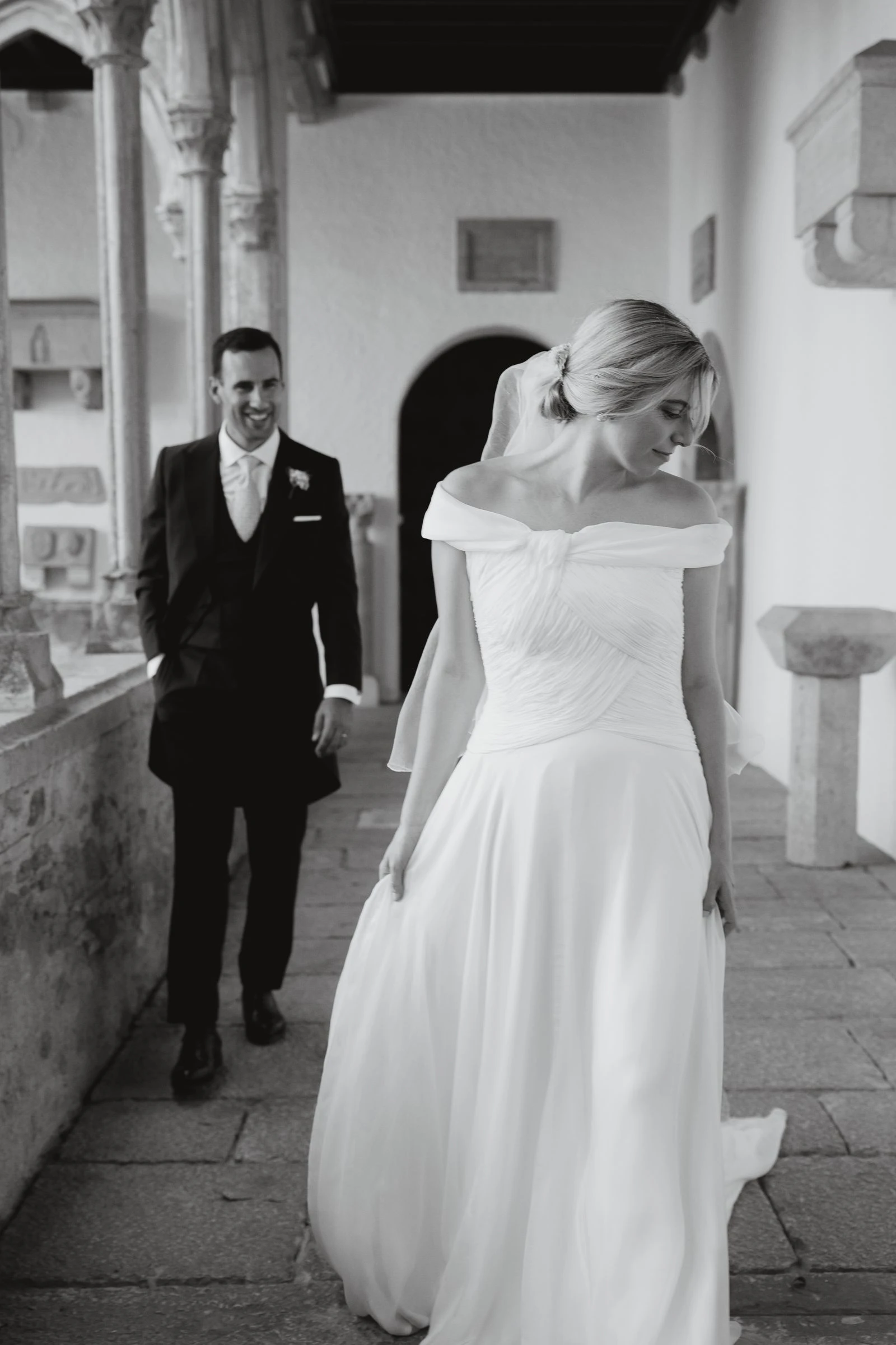 Novios bajando las escaleras de un claustro, en blanco y negro