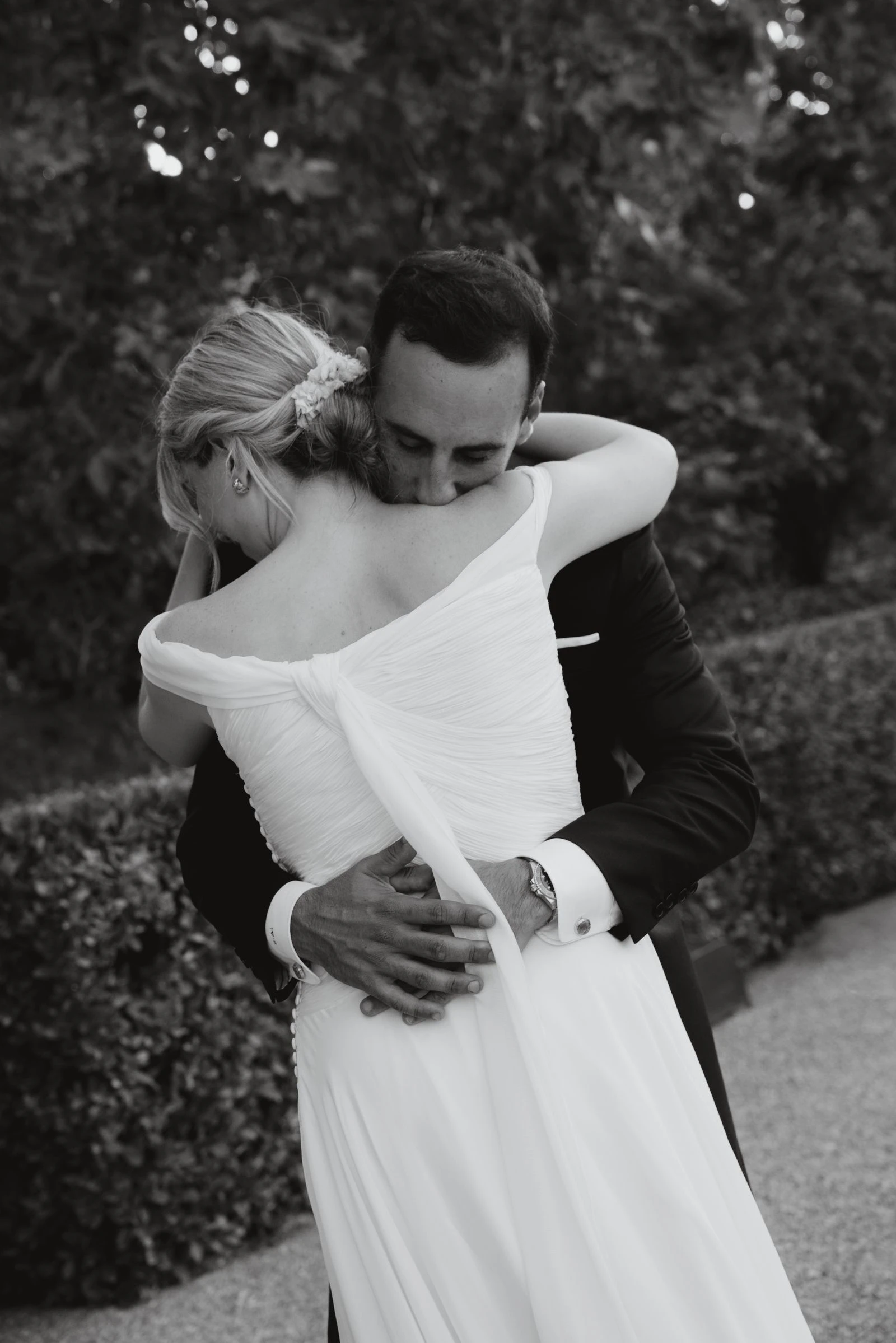 Novios abrazados en el jardín, en blanco y negro
