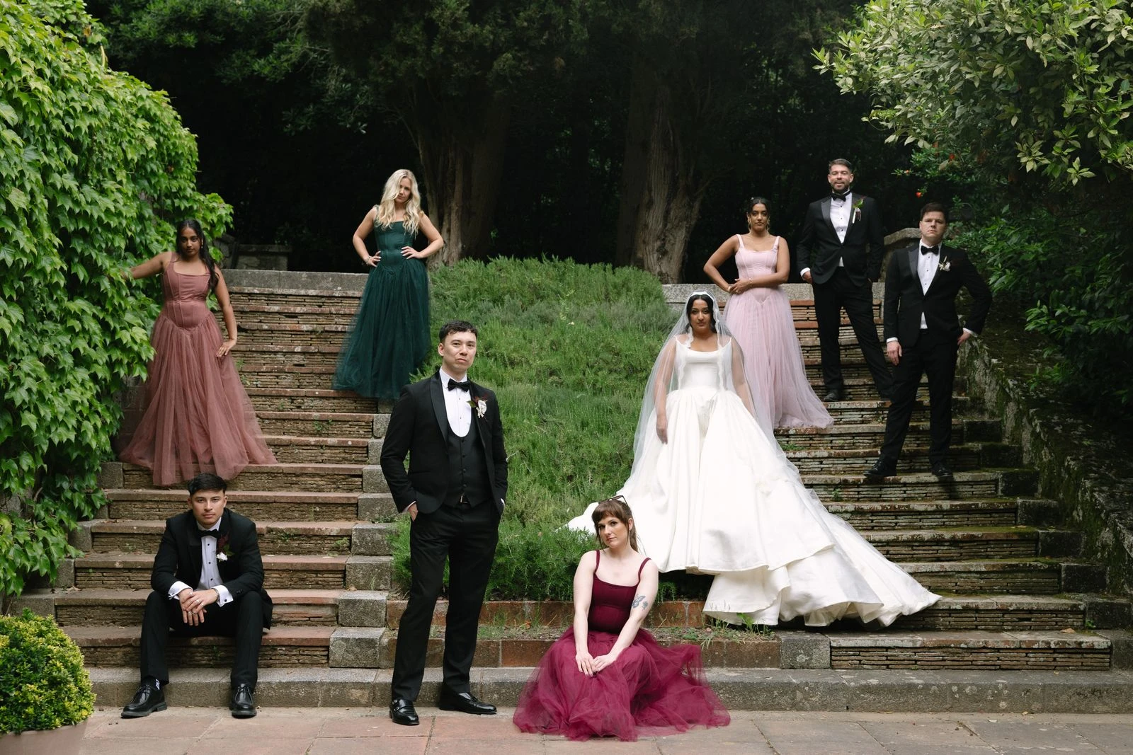 Los novios y su cortejo posando en la escalinata del jardín de Bell Recó