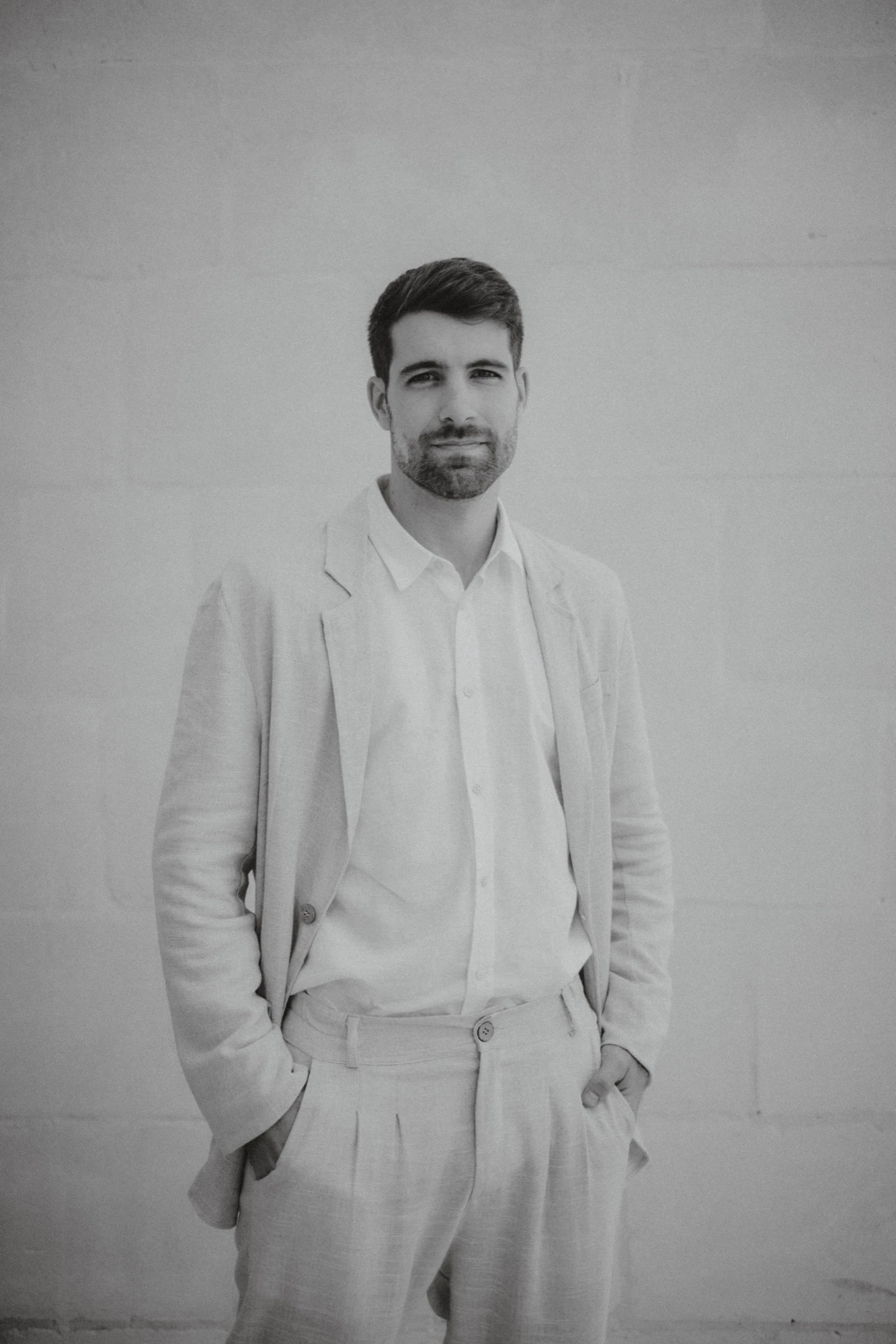 Retrato de Jona Martín, fotógrafo de bodas, en blanco y negro con traje claro