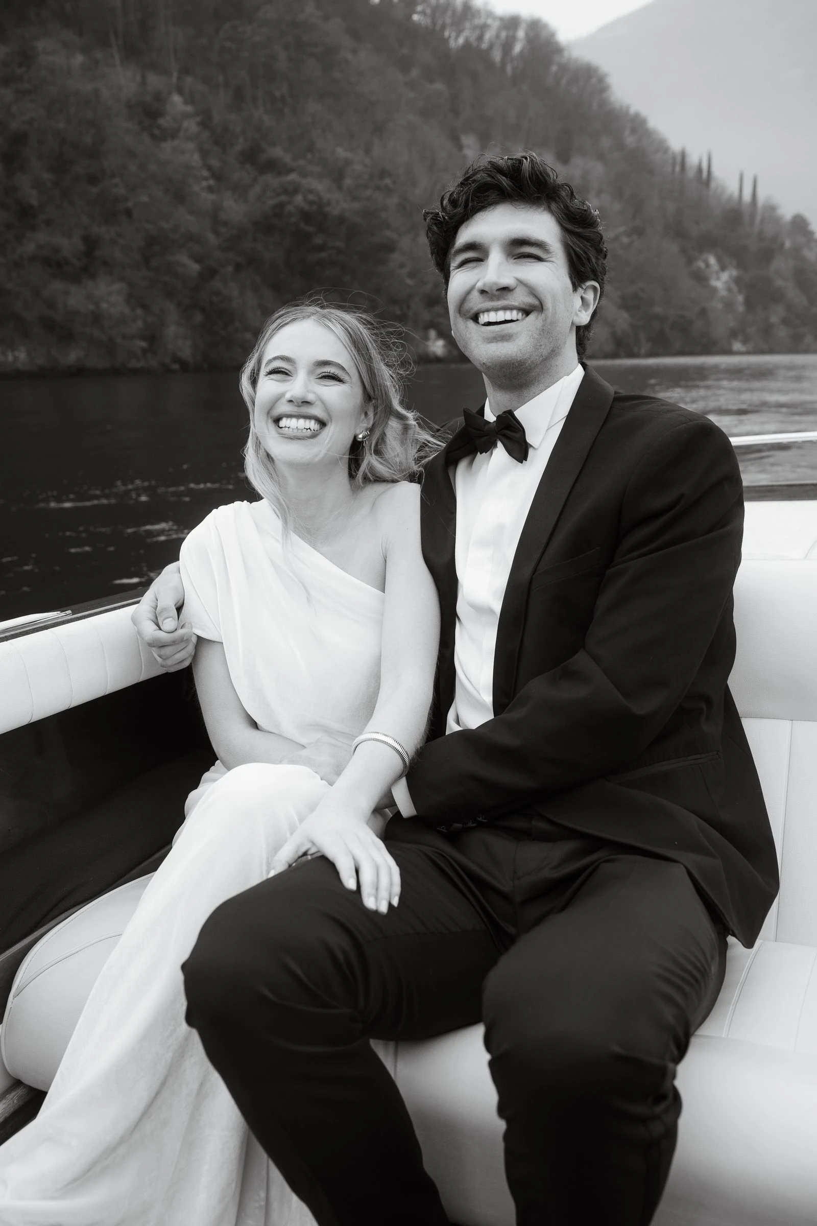 Novios sentados en la lancha, riendo, en blanco y negro