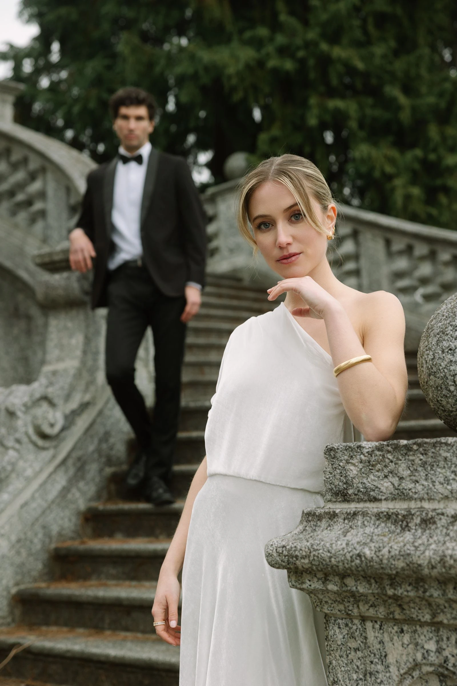 Novios en la escalinata de piedra de una villa