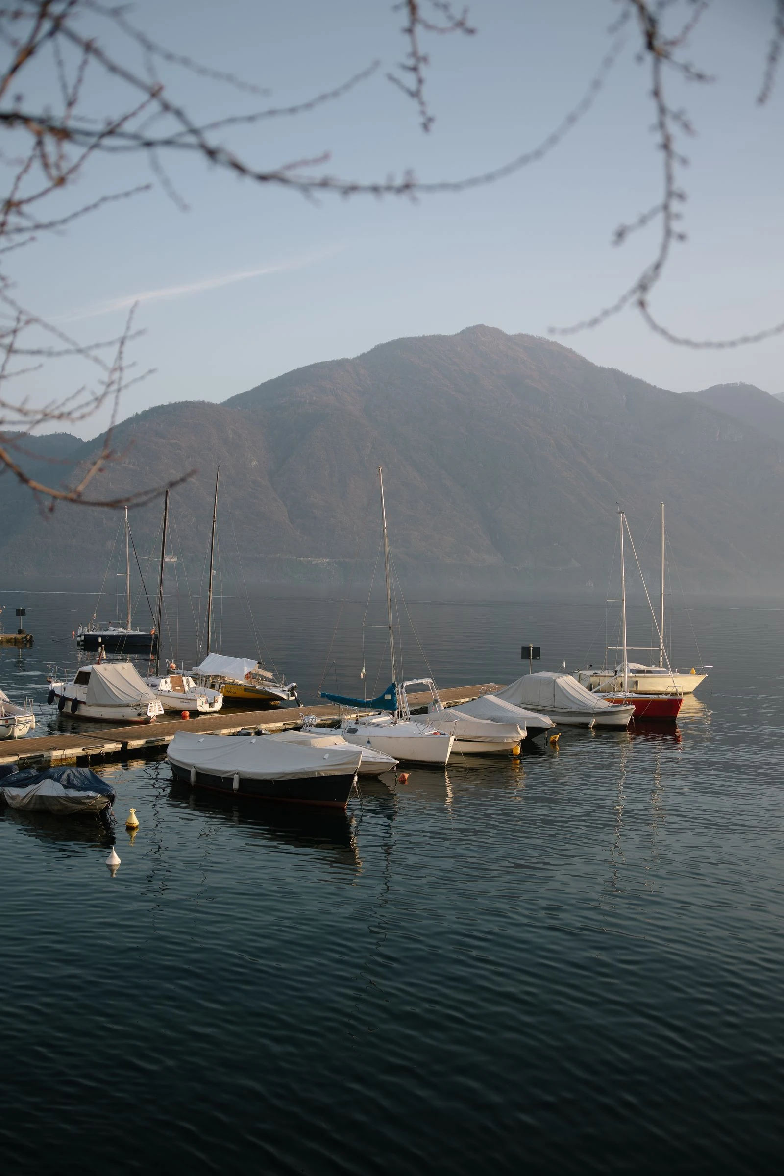 Barcas amarradas en el lago con las montañas al fondo