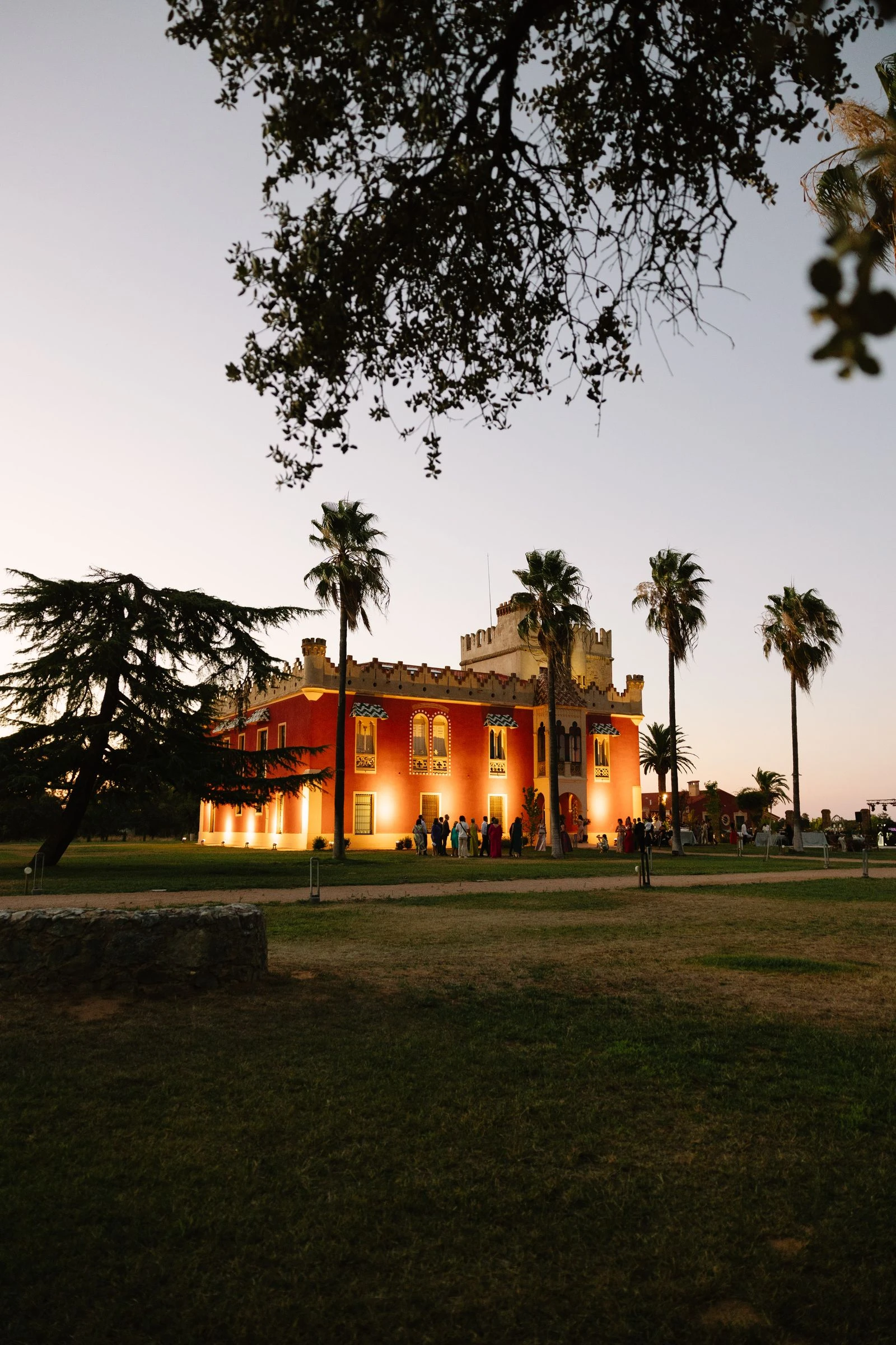 Masía iluminada al atardecer entre palmeras