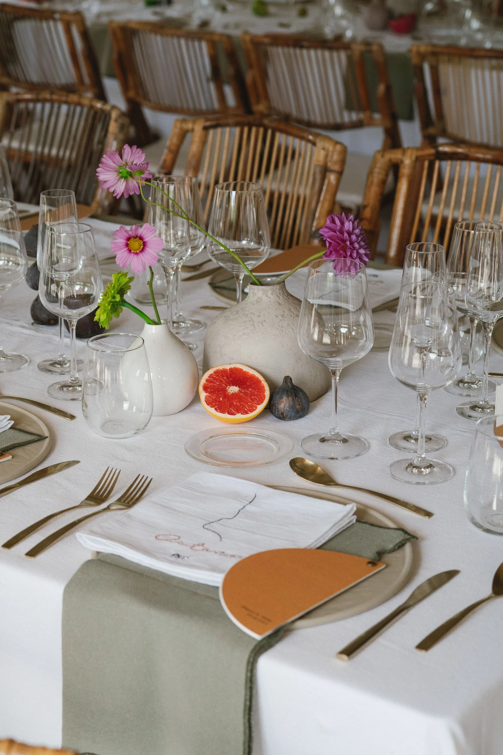 Detalle de mesa con pomelo, velas y flores de colores