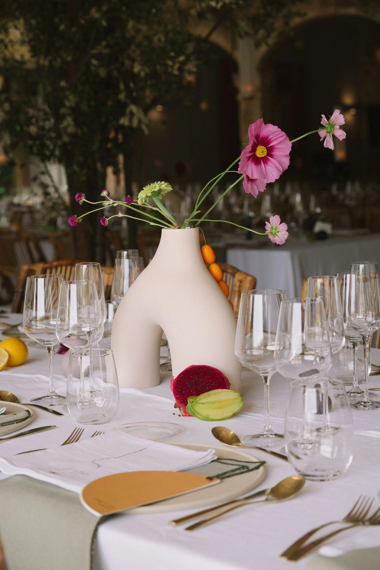 Centro de mesa con jarrón escultórico y flores silvestres