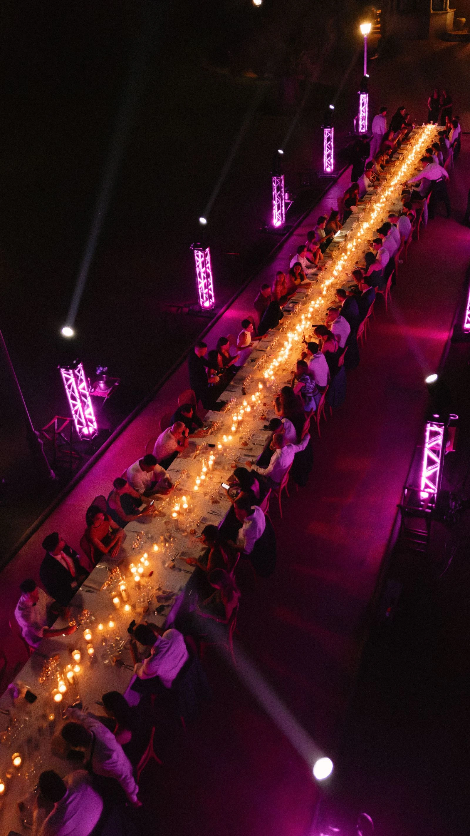 Mesa larga del banquete con luz magenta durante la fiesta